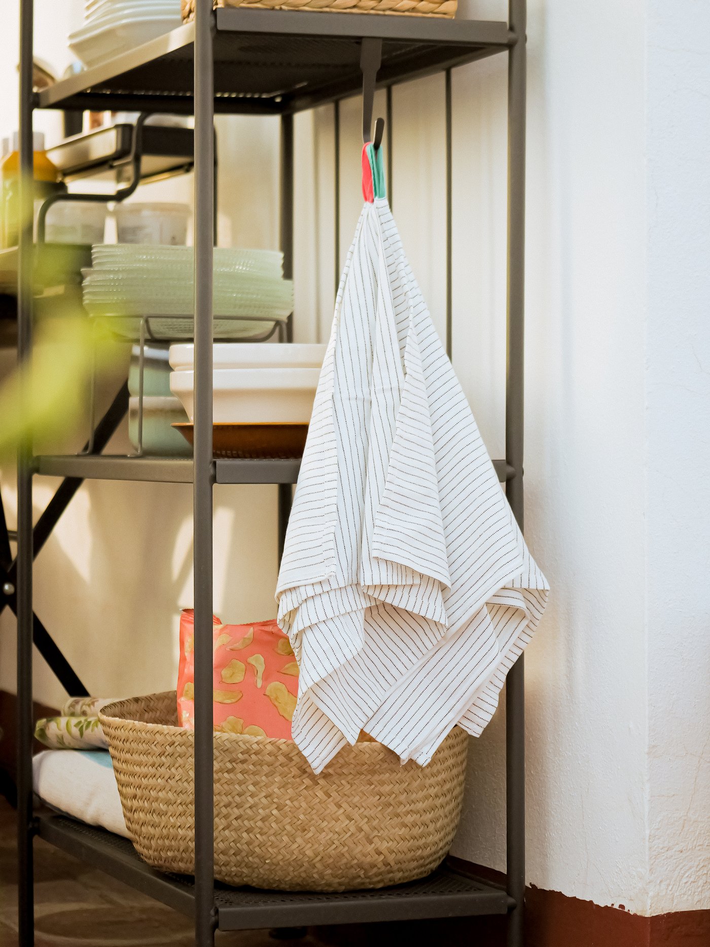 Un set di tovaglioli GRUPPERA è appeso al gancio di un tavolino.