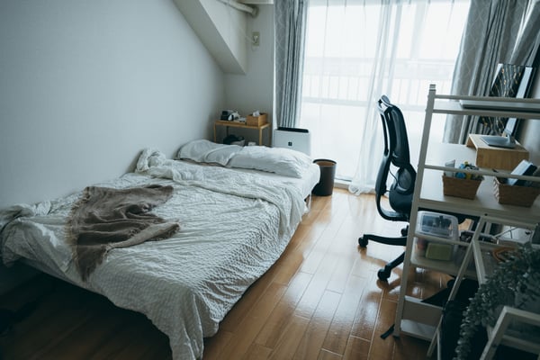 白い壁と白い寝具、家具が置かれた部屋
