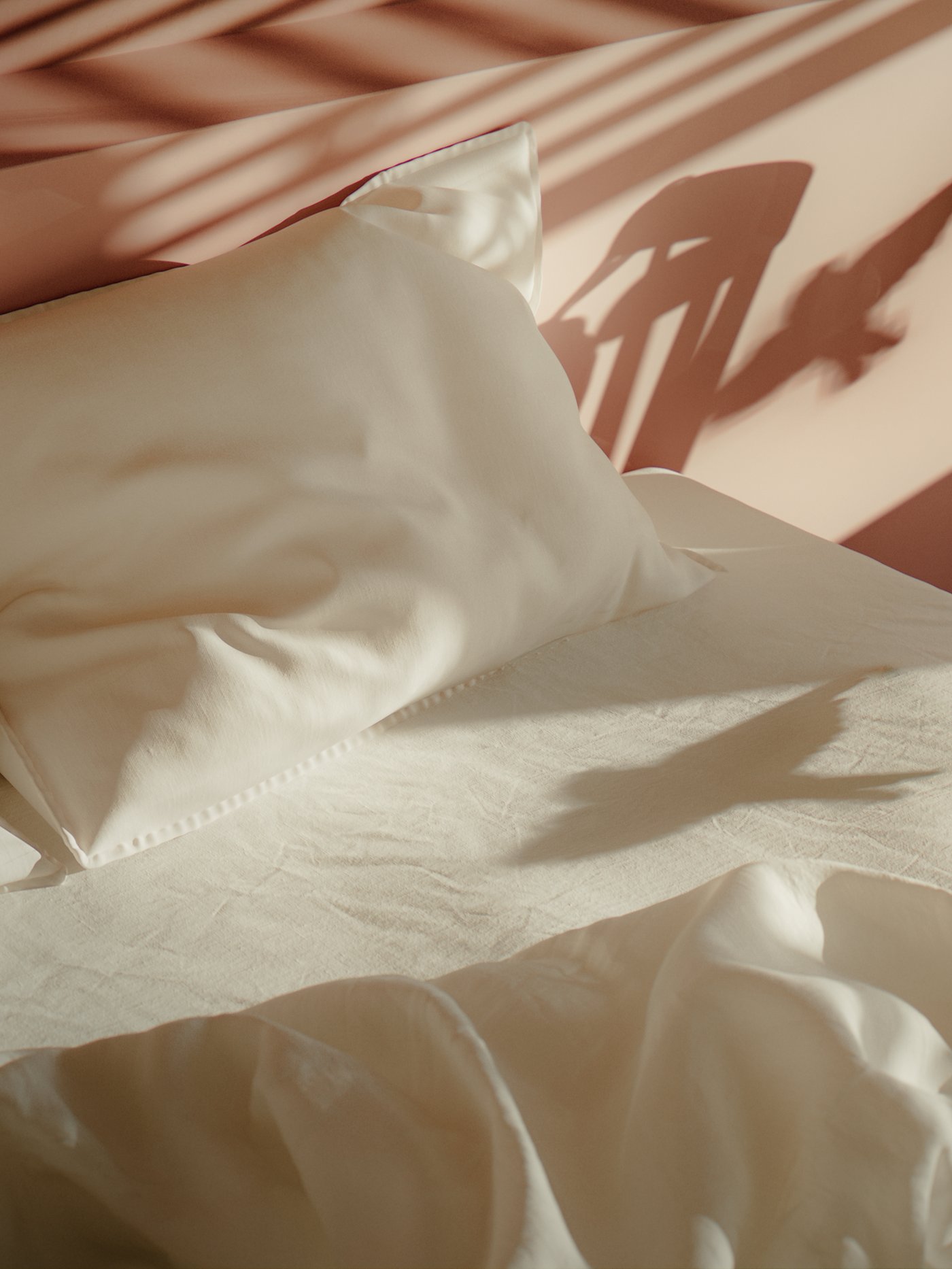 Una almohada con una funda de almohada blanca DYTÅG se encuentra sobre una cama con una sábana blanca DVALA cerca de un edredón con una funda nórdica blanca DYTÅG.
