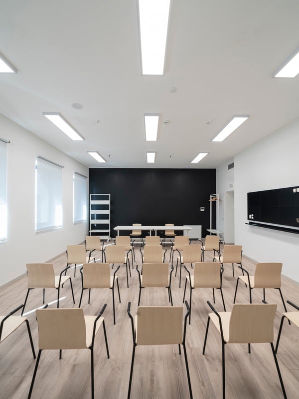 Area della biblioteca comunale di Brescia Roncadelle con 4 file da 5 file di sedie da riunioni LÄKTARE. Sul fondo c’è un postazione creata con due scrivanie MITTZON e due sedie da riunione LÄKTARE. Accanto ai lati uno scaffale su rotelle e un appendiabiti.