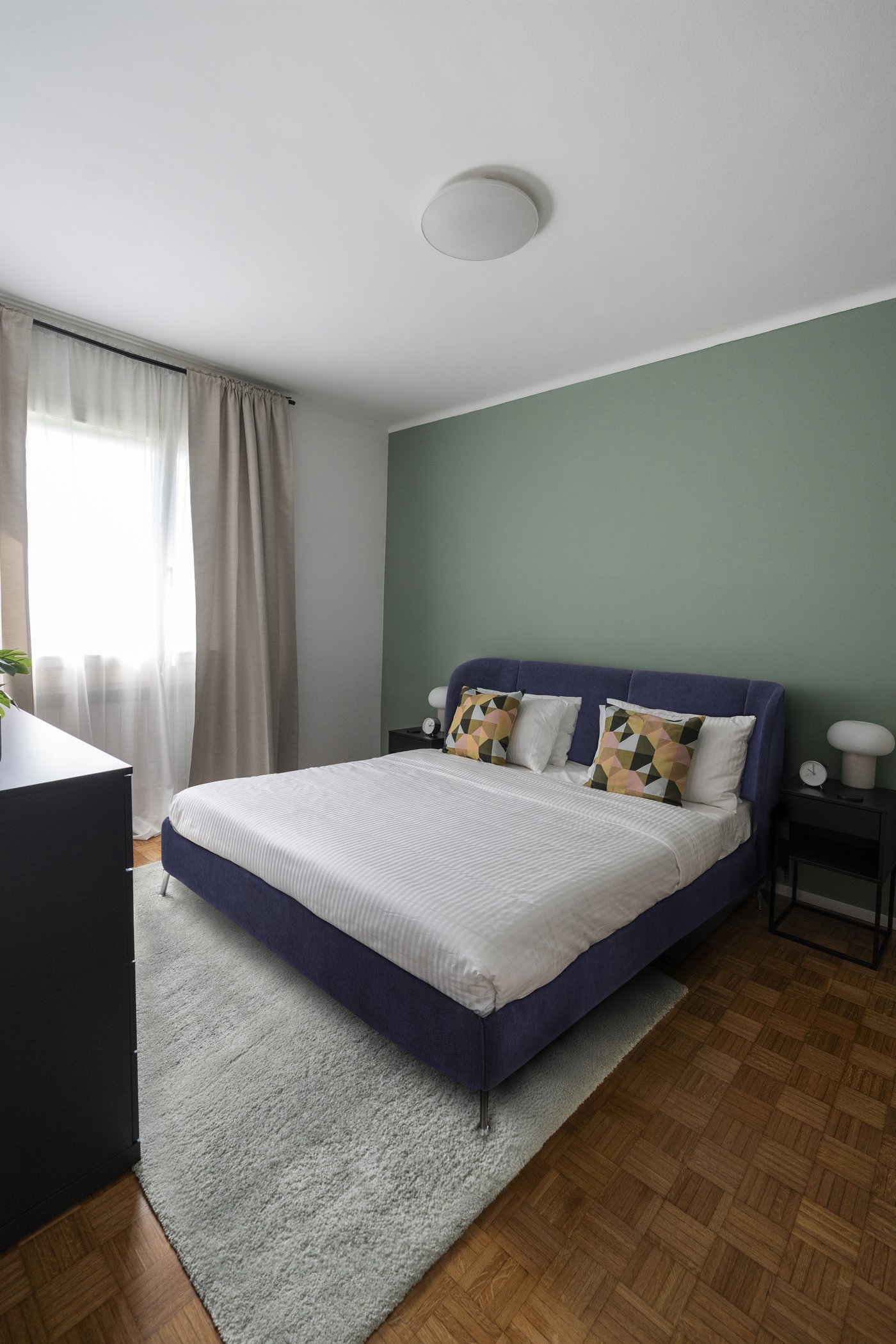 Una luminosa camera da letto con struttura letto imbottita TUFJORD blu.