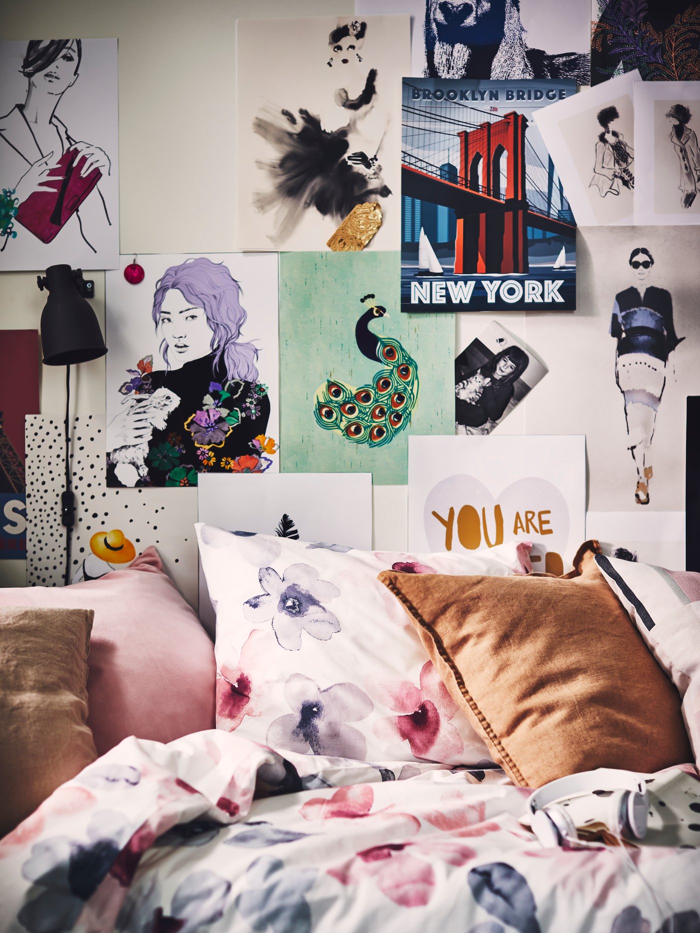 Krevet s LAPPNYCKLAR jorganskom navlakom i jastučnicom i zid prekriven ilustracijama i BILD posterima.