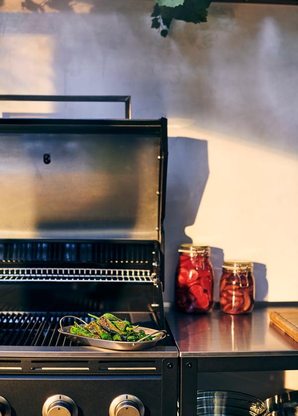 Grilovací podnos GRILLTIDER s grilovanými zelenými paprikami ležící na grilu KLASEN.
