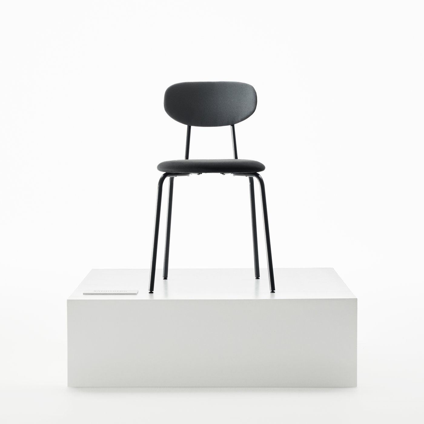Une chaise de salle à manger SANDSBERG de couleur noire, placée sur une scène blanche de manière à mettre en valeur son design minimaliste.