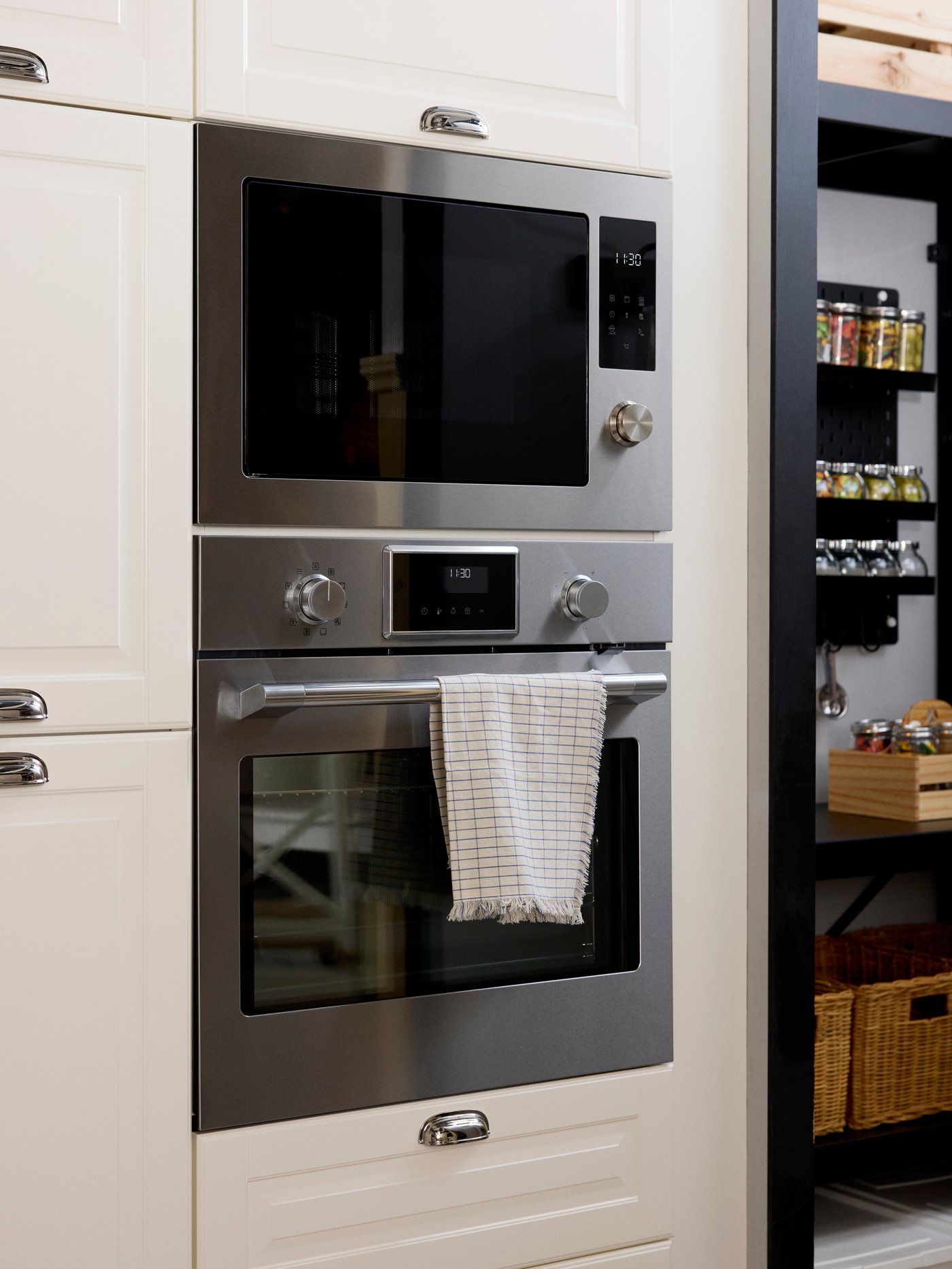 A traditional oven and microwave in a tall kitchen cabinet.