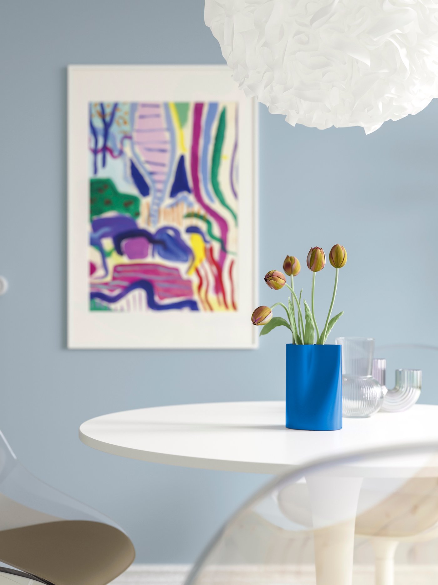 Eine leuchtend blaue CHILIFRUKT Vase/Gießkanne auf einem weißen, runden Esstisch