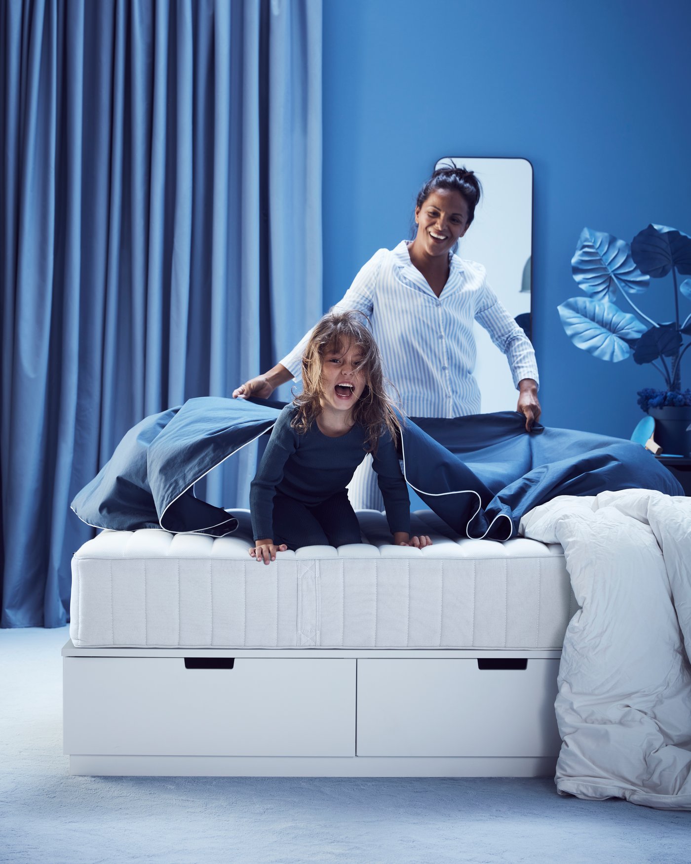 Un materasso a molle insacchettate VALEVÅG rigido/azzurro nella camera da letto