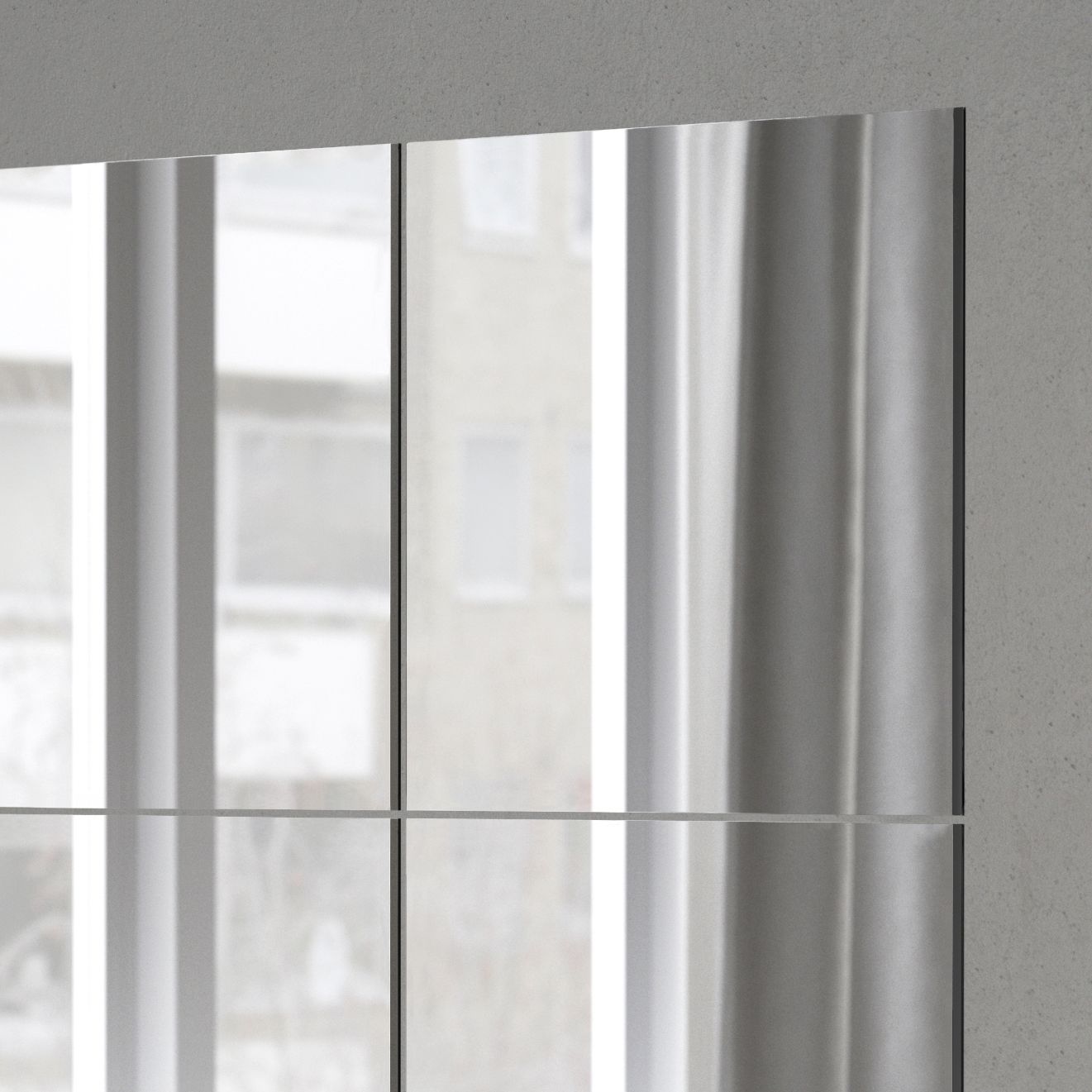 Närbild på fyra fyrkantiga speglar på en grå vägg.