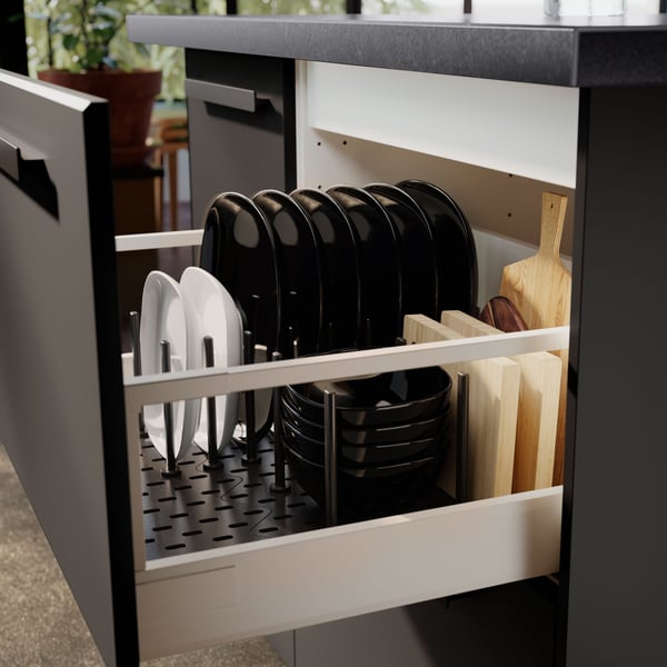 Black and white bowls and plates are neatly stacked in a kitchen drawer with an UPPDATERA pegboard drawer organiser.