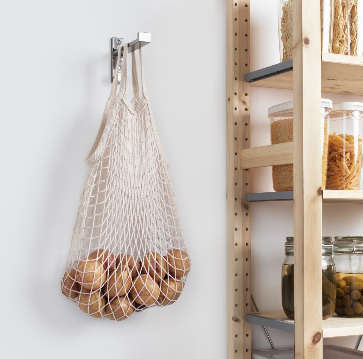 Et net med løg hænger på en krog.