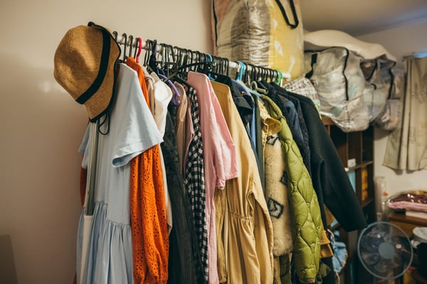 ラックにハンガーに掛かった服が並んでいる。