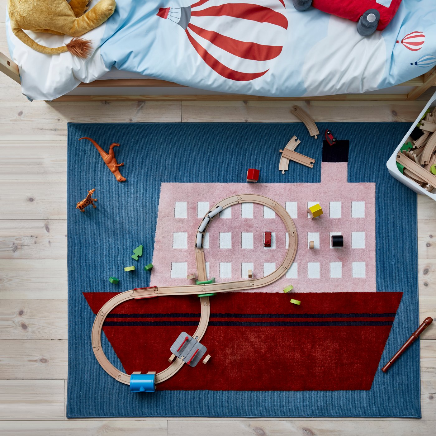 Ein bunter Kinderteppich liegt in einem Kinderzimmer.