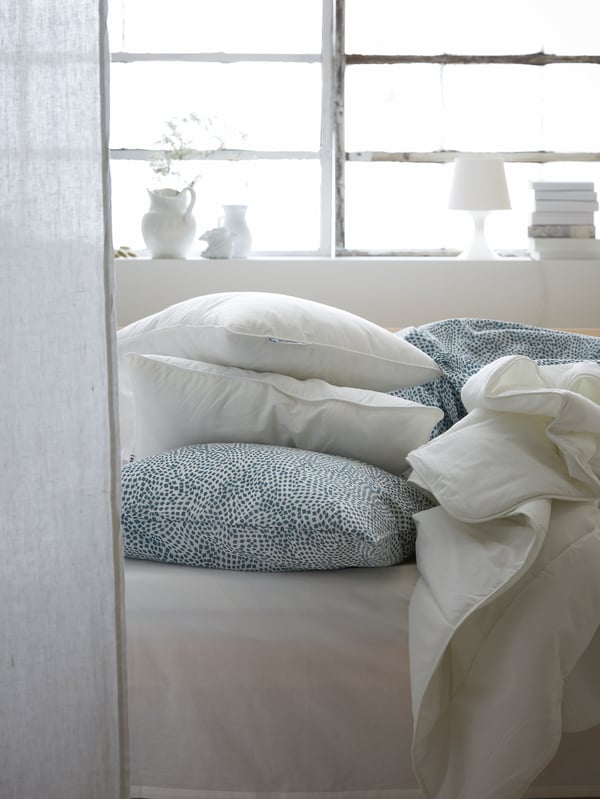 A white/blue TRÄDKRASSULA duvet cover and pillowcase in the bedroom