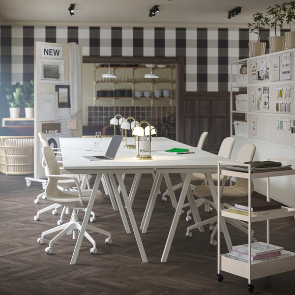 An updated office space with four white TROTTEN desks grouped together, paired with beige/white LÅNGFJÄLL conference chairs.