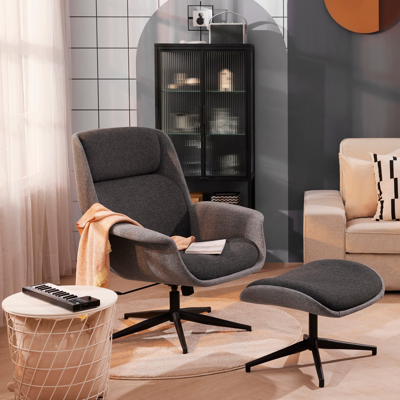 Poltrona e poggiapiedi girevole ÄLEBY grigio in un salotto