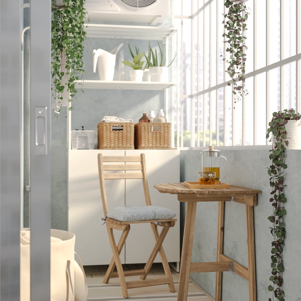 Wintergarten mit einem ASKHOLMEN Wandtisch in Akazie/Klösan Blau zu sehen sowei Faltzylinder