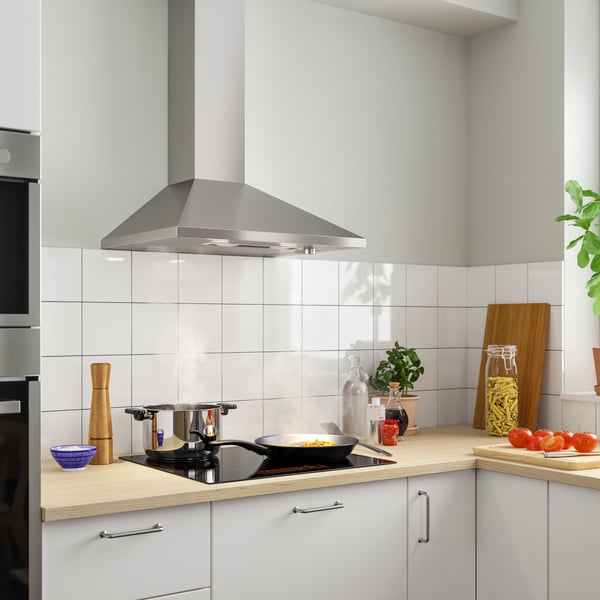 A stainless steel RYTMISK wall mounted extractor hood in the kitchen