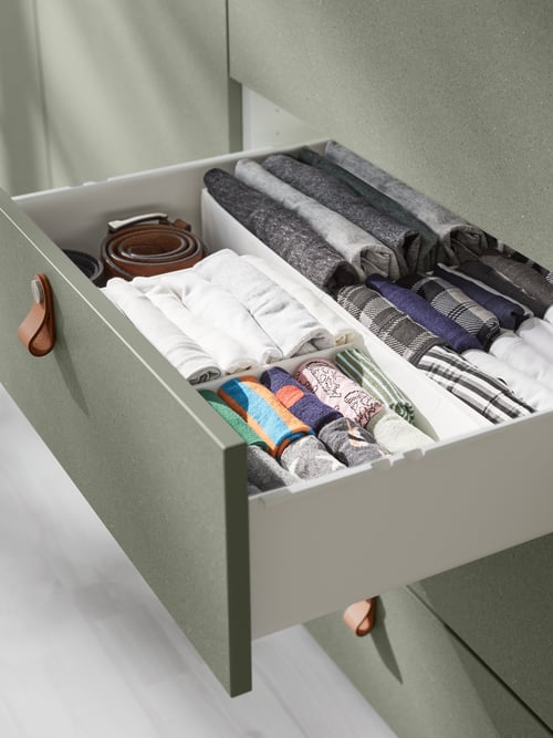 Bedroom with a rectangular box with compartments made of recycled polyester stored inside a drawer with grey drawer front.