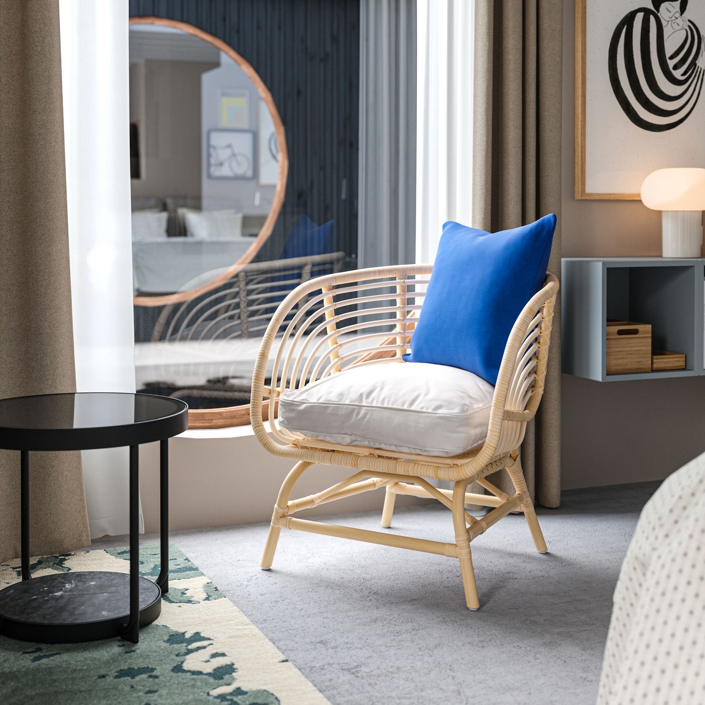 Ett hotellrum i husbåtsstil med en BUSKBO rottingfåtölj och en kudde med ett blått kuddfodral bredvid ett stort, runt fönster.