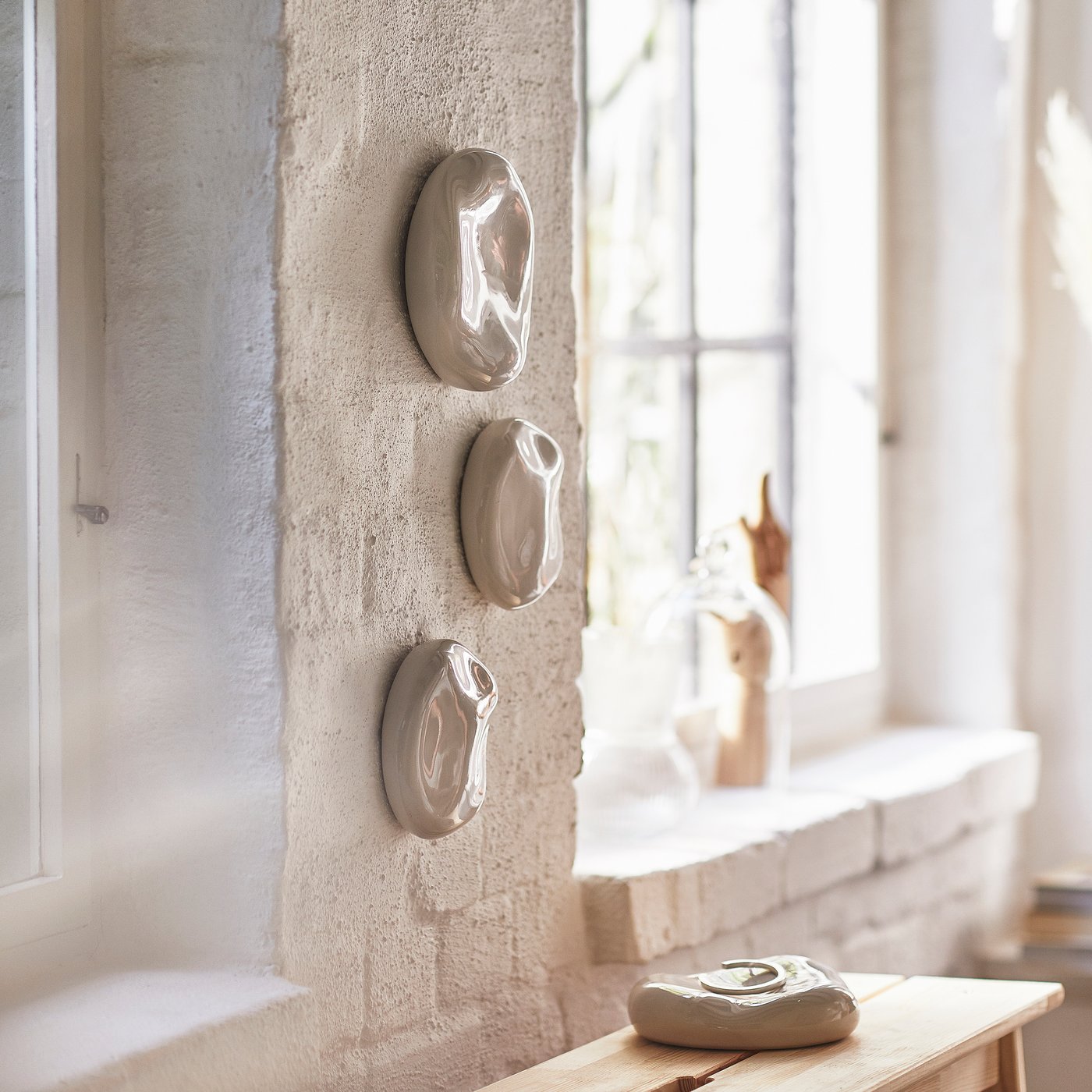 Steindekorationen hängen an einer Wand.