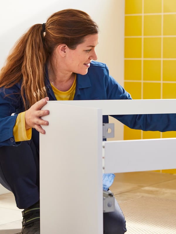 Femme en train de monter un meuble IKEA.