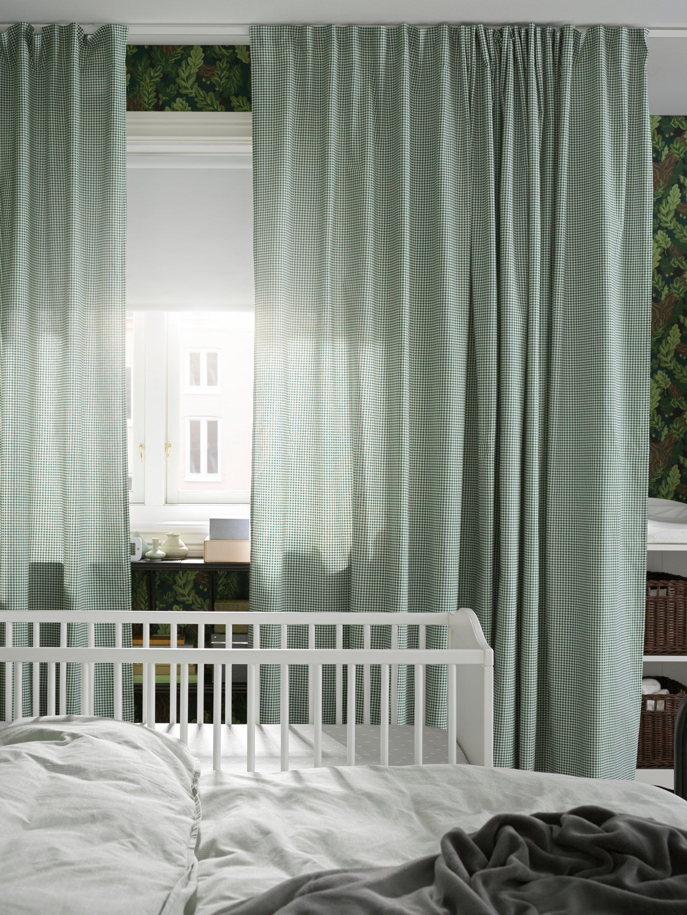 SMÅGÖRA rácsos ágy egy SAGSTUA dupla ágy mellett, közel egy ablakhoz, ami ORDENSFLY függönyökkel és egy FRIDANS redőnnyel van felszerelve.