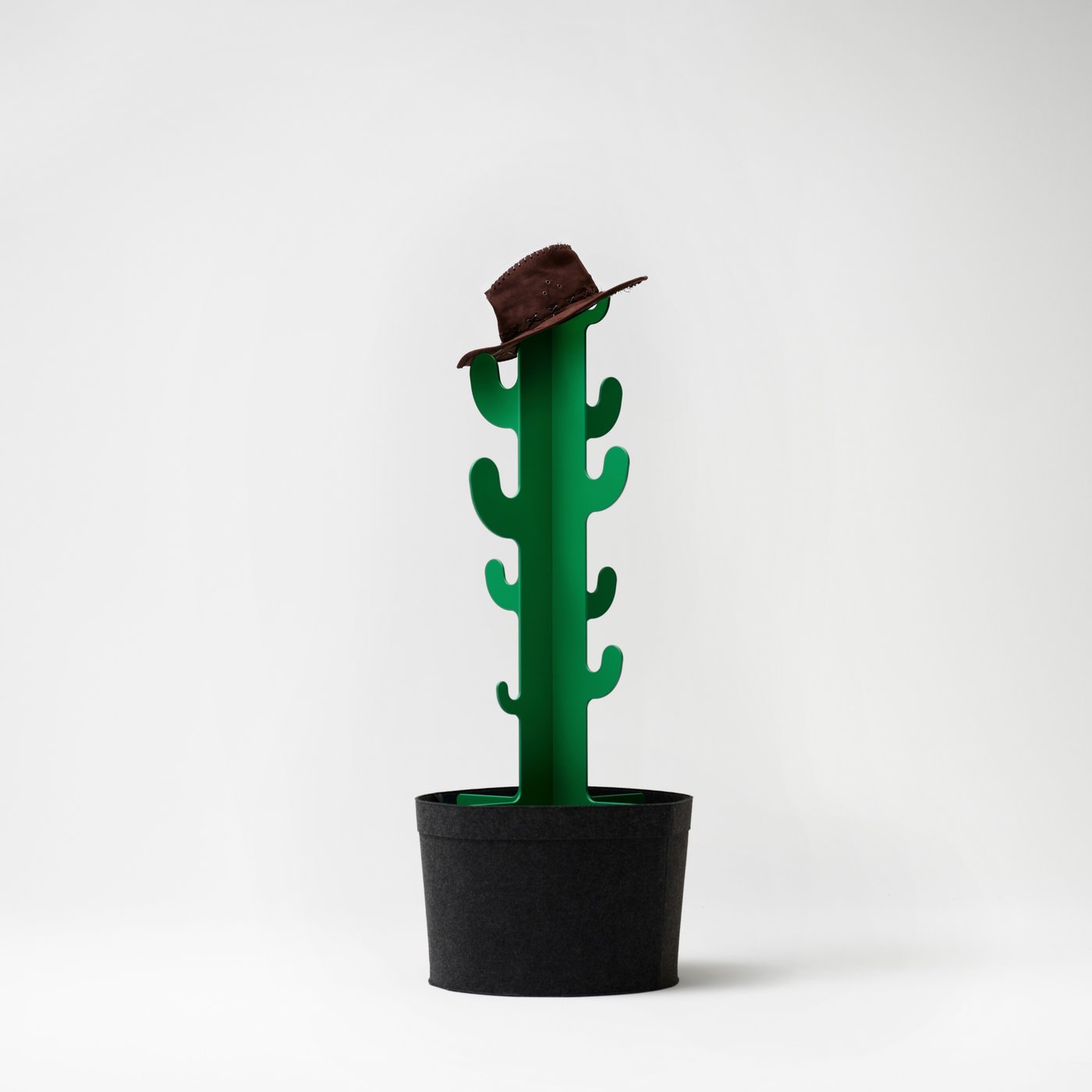 Een groene GREJSIMOJS kapstok in de vorm van een cactus met een zwart hoedje aan één van de haakjes.