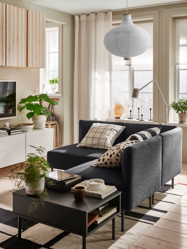 Modular LILLEHEM seating and a TUNNSTA side table stand in a living room on a RASTPLATS rug under a RISBYN pendant lampshade.