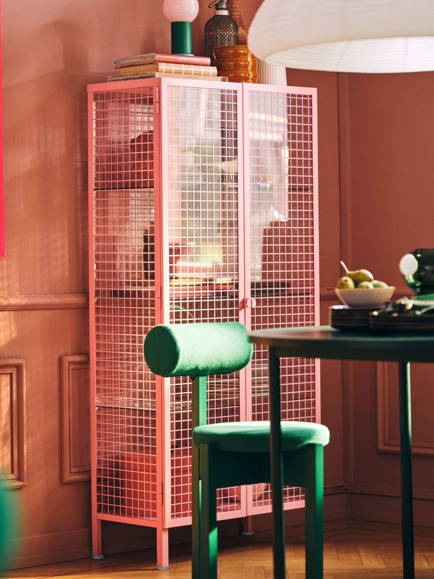 Et lyserødt IKEA PS 2026 skab med glaslåger.