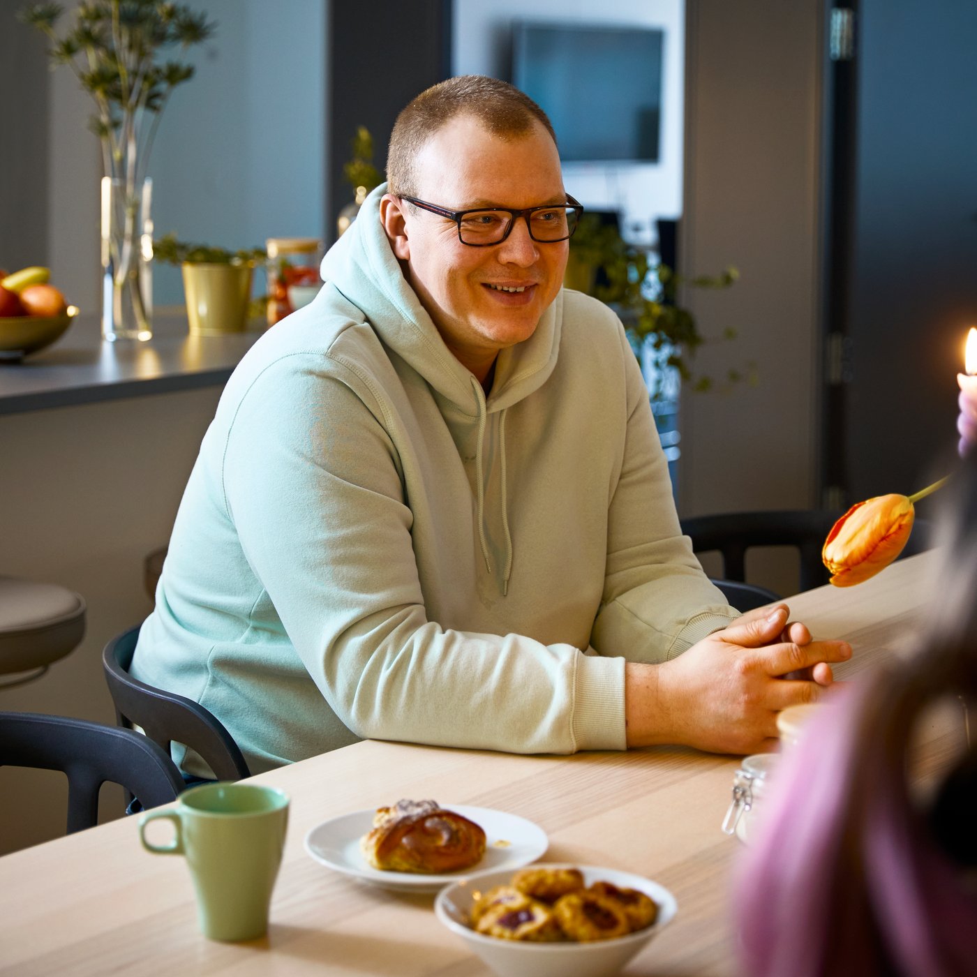 En mann sitter ved et bord i en cafe. 