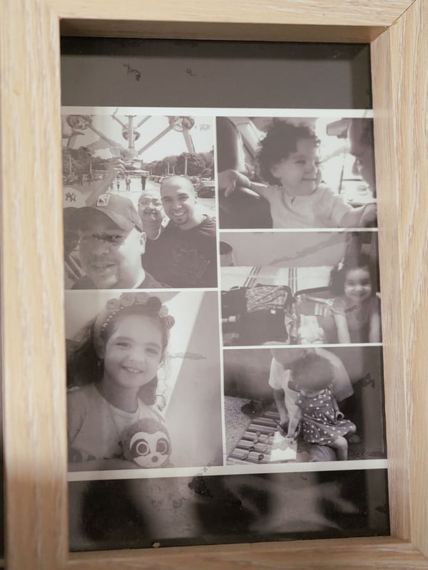 A collage of black and white photographs is displayed within a wooden frame.