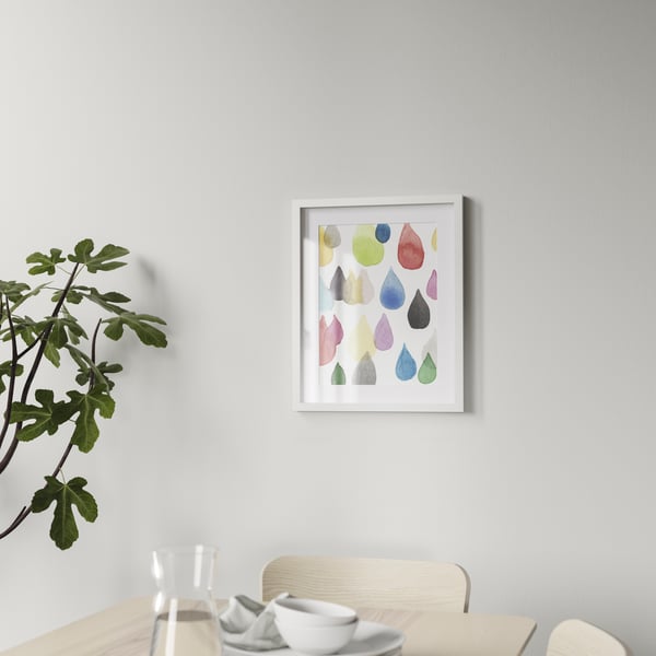 An IKEA RÖDALM white picture frame mounted on the wall on top of a sideboard in the living room. 
