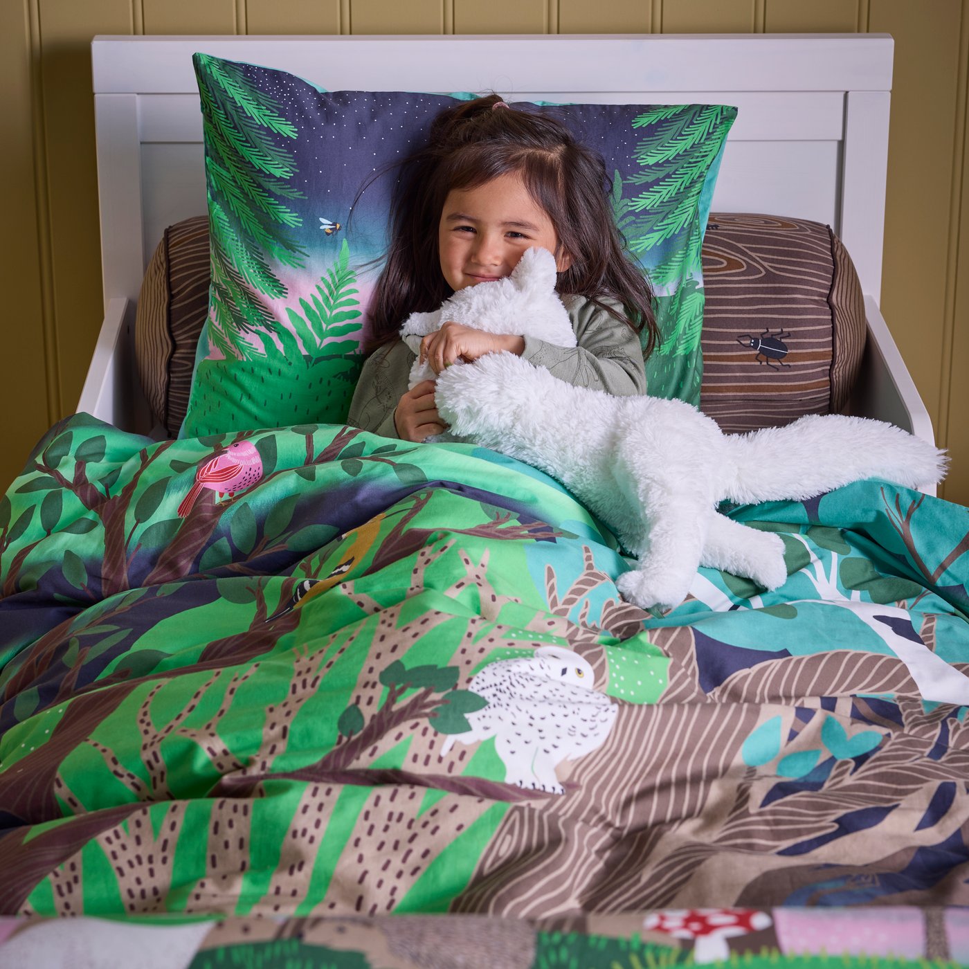 A cylinder shaped/brown SKOGSDUVA cushion in the childrens room