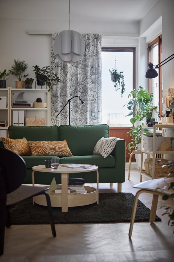 En grøn PÄRUP sofa står i en stue med et stort vindue.