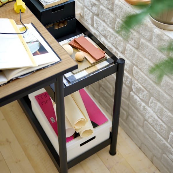 A removable storage unit from a MULLSJÖ desk with colour samples, an anthracite FJÄDERHARV mini chest and a paper box.
