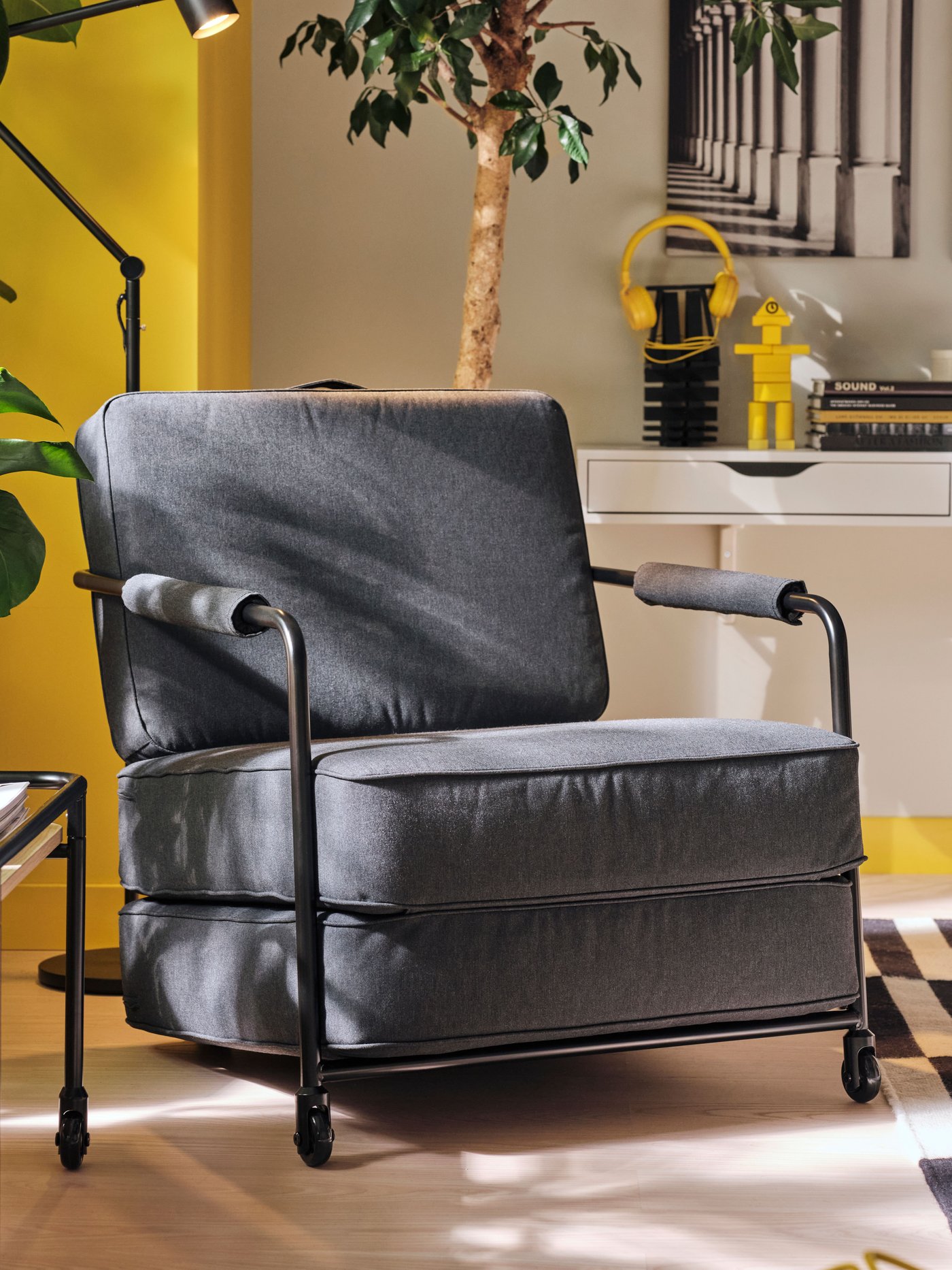 A light ash effect/black BRÄNNBOLL side table on castors in the living room