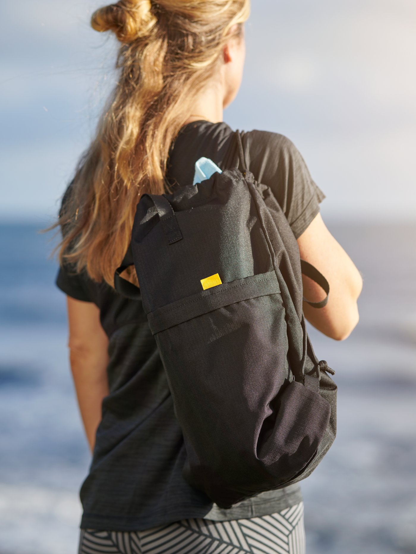 Sac à dos STARTTID sur le dos d’une fille qui regarde au loin.