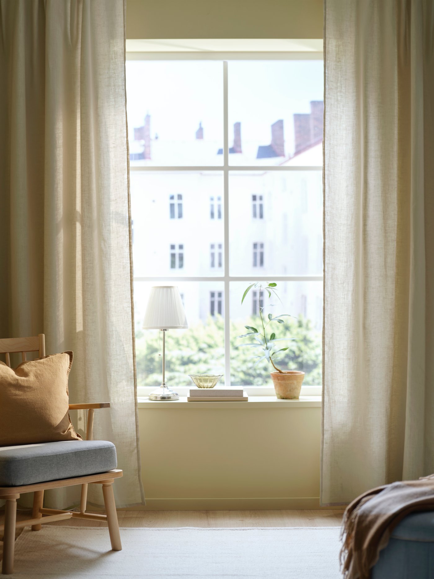 リビングルームでアームチェアと窓にカーテン