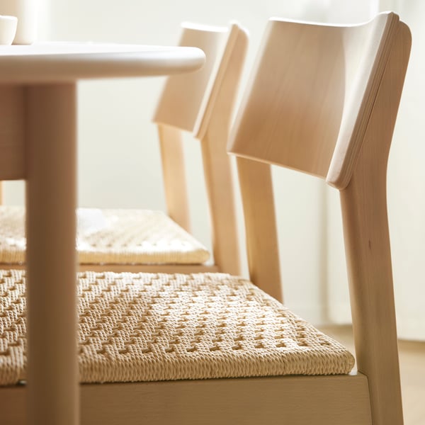 Two SKANSNÄS light beech chairs stand at a light beech/veneer SKANSNÄS round extendable table in a sunny room.