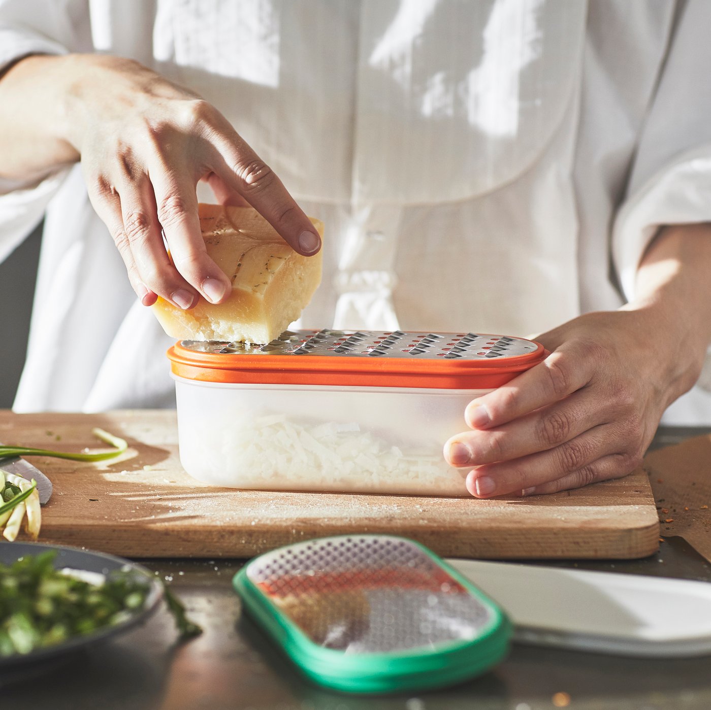 A mixed colours UPPFYLLD grater with container in the kitchen