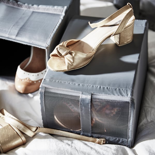 A close-up of SKUBB shoe boxes on the top shelf of a closet.