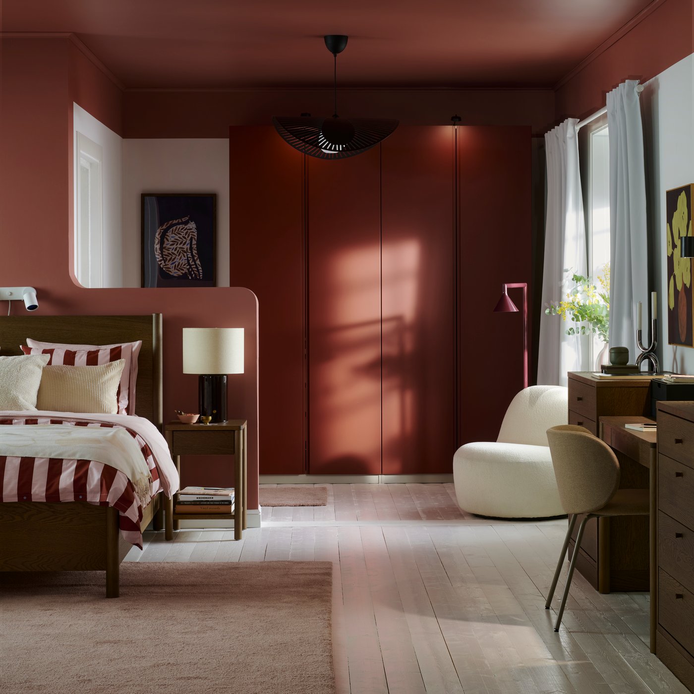 A bedroom with white floors and a dark brown TONSTAD bed with striped bedding and PAX wardrobe with orange VIKANES doors.