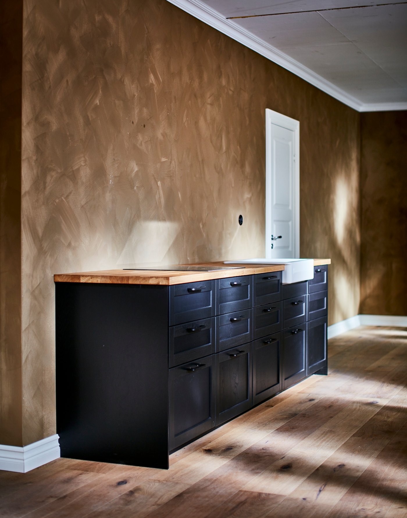 Eine Küche aus METOD Unterschrankkorpussen, die schwarz angestrichen und mit den LERHYTTAN Fronten versehen wurden.