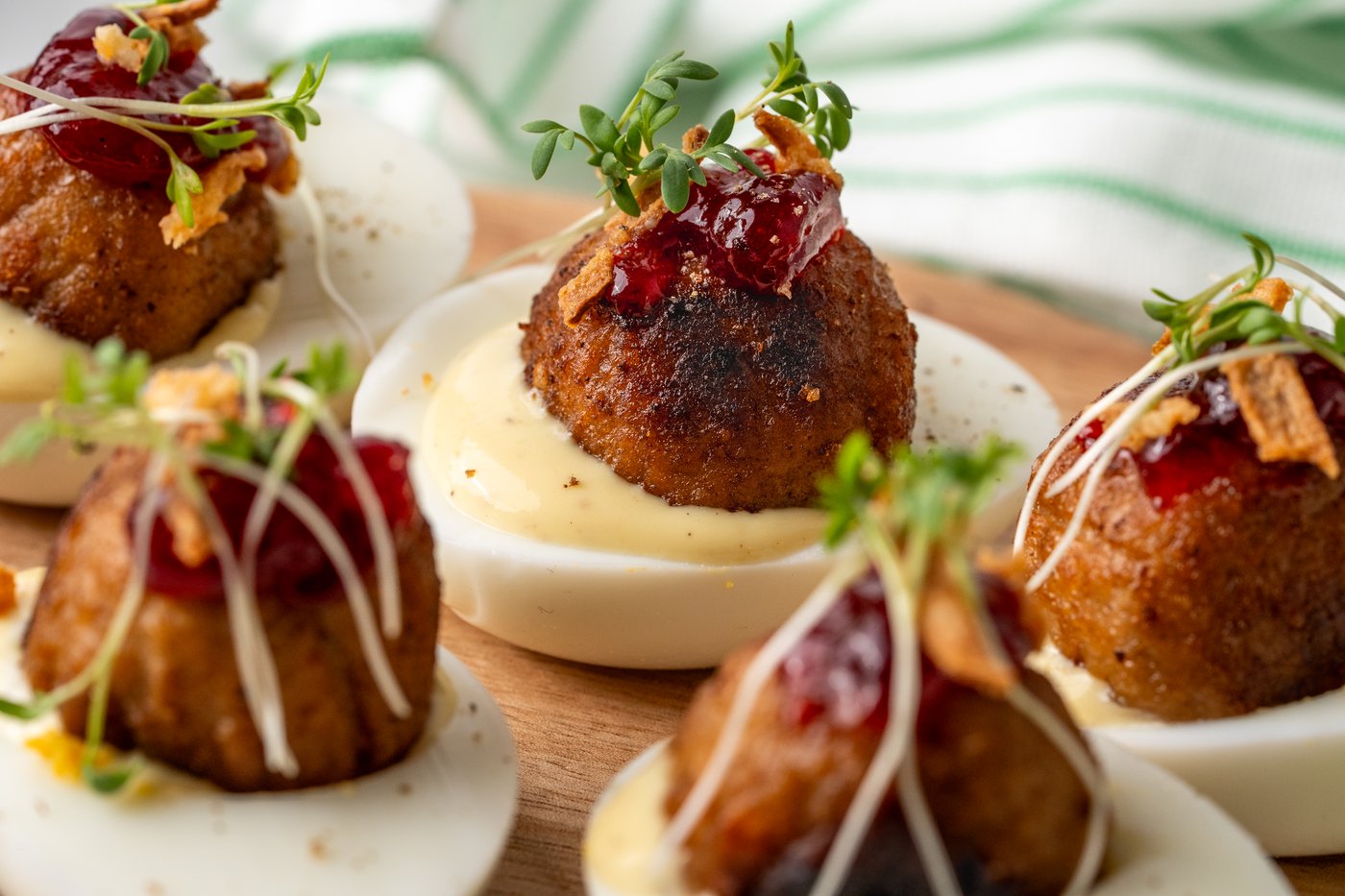 Mit Plantballs gefüllte Eier, die auf einem Holzbrett serviert werden.