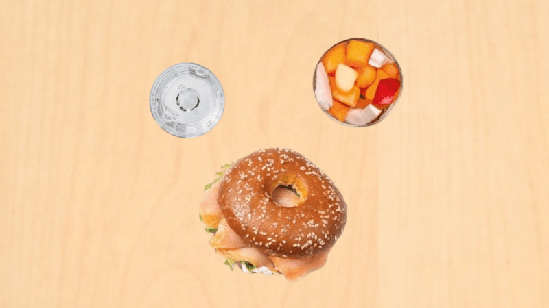 Un bagel al salmone, acqua e macedonia