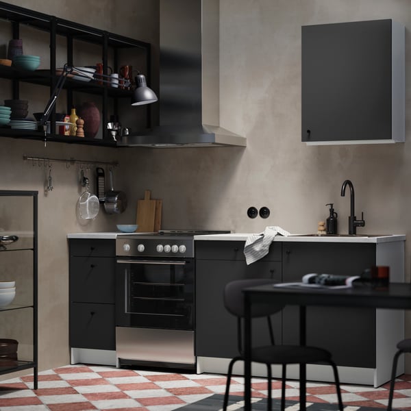 A dark grey KNOXHULT wall cabinet with a door, set in a modern kitchen featuring a sleek design and minimalist decor.