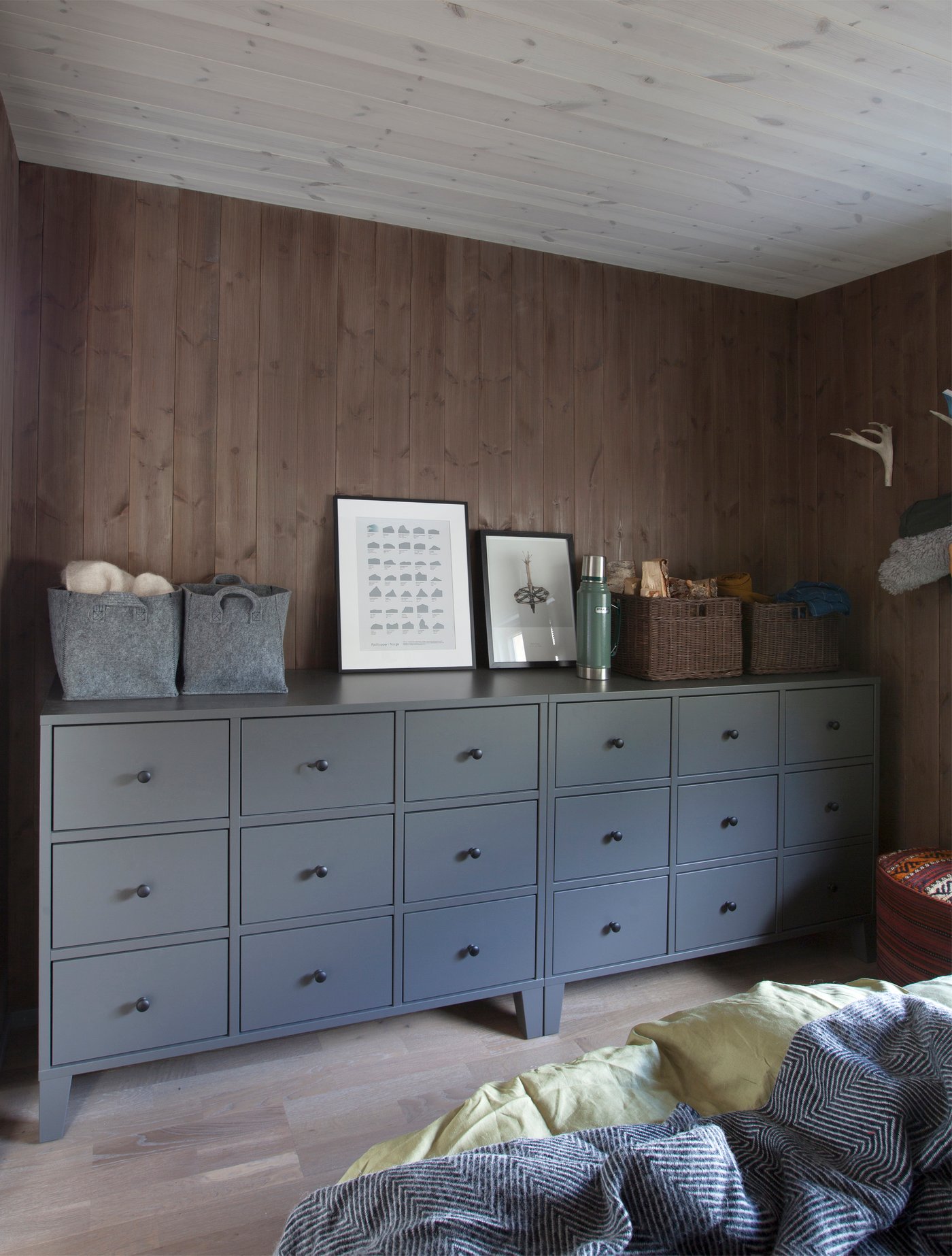 Her er flere kommoder plassert på en rekke langs veggen. Hver kommode har ni solide skuffer, slik at det blir godt med plass til oppbevaring, og enkelt å holde styr på klær og utstyr.