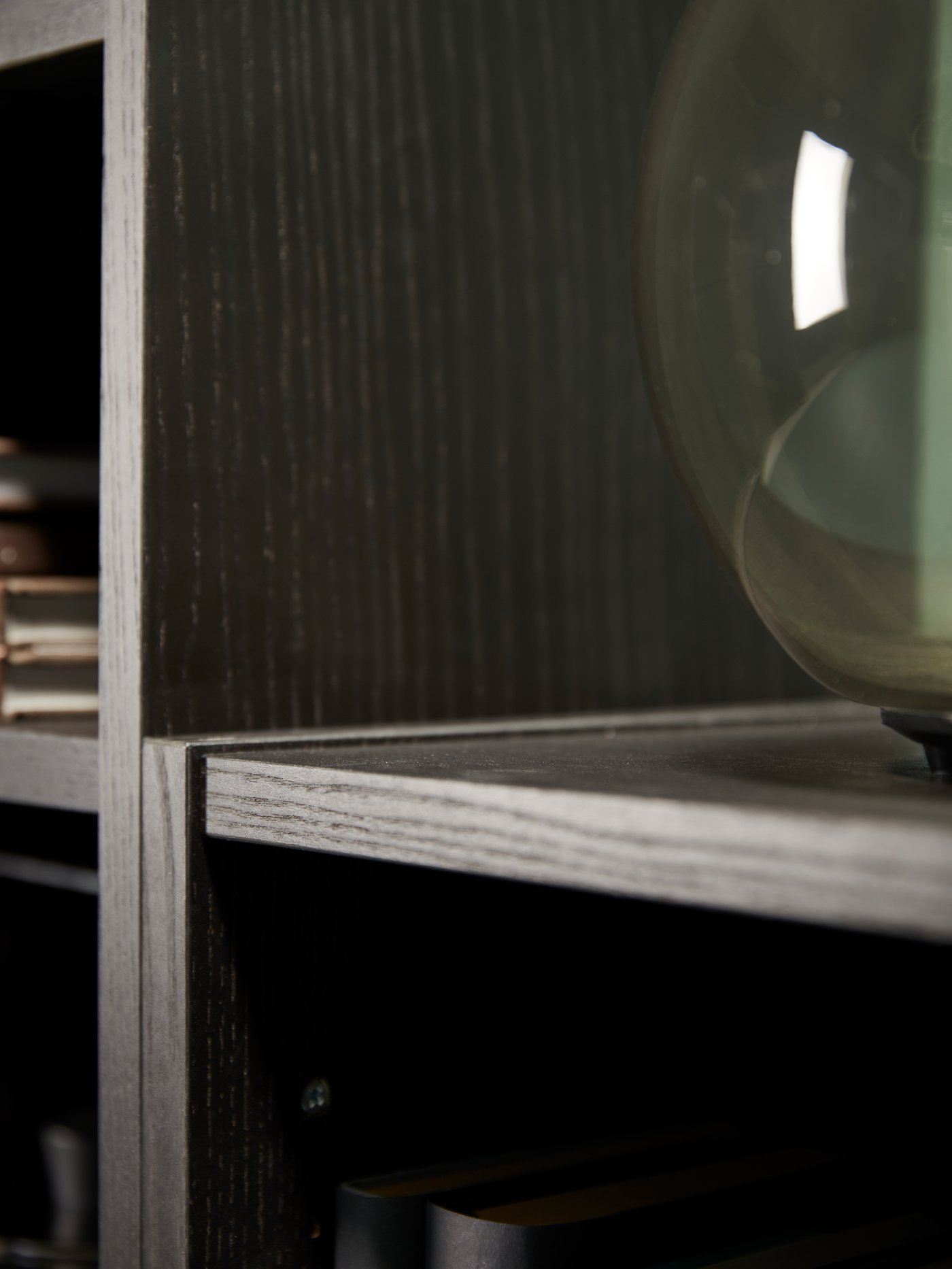 مكتبة BILLY باللون الأسود/البني. على أحد رفوفها مزهرية زجاجية خضراء.