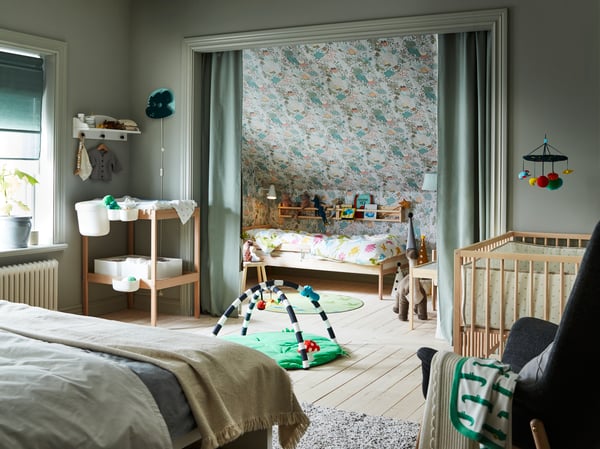 A bedroom with children's furniture such as a SNIGLAR changing table and cot