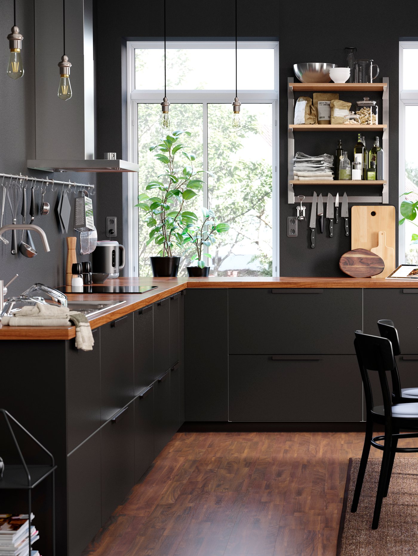 Cuisine industrielle noir et bois avec plancher en bois, avec une fenêtre en fond.